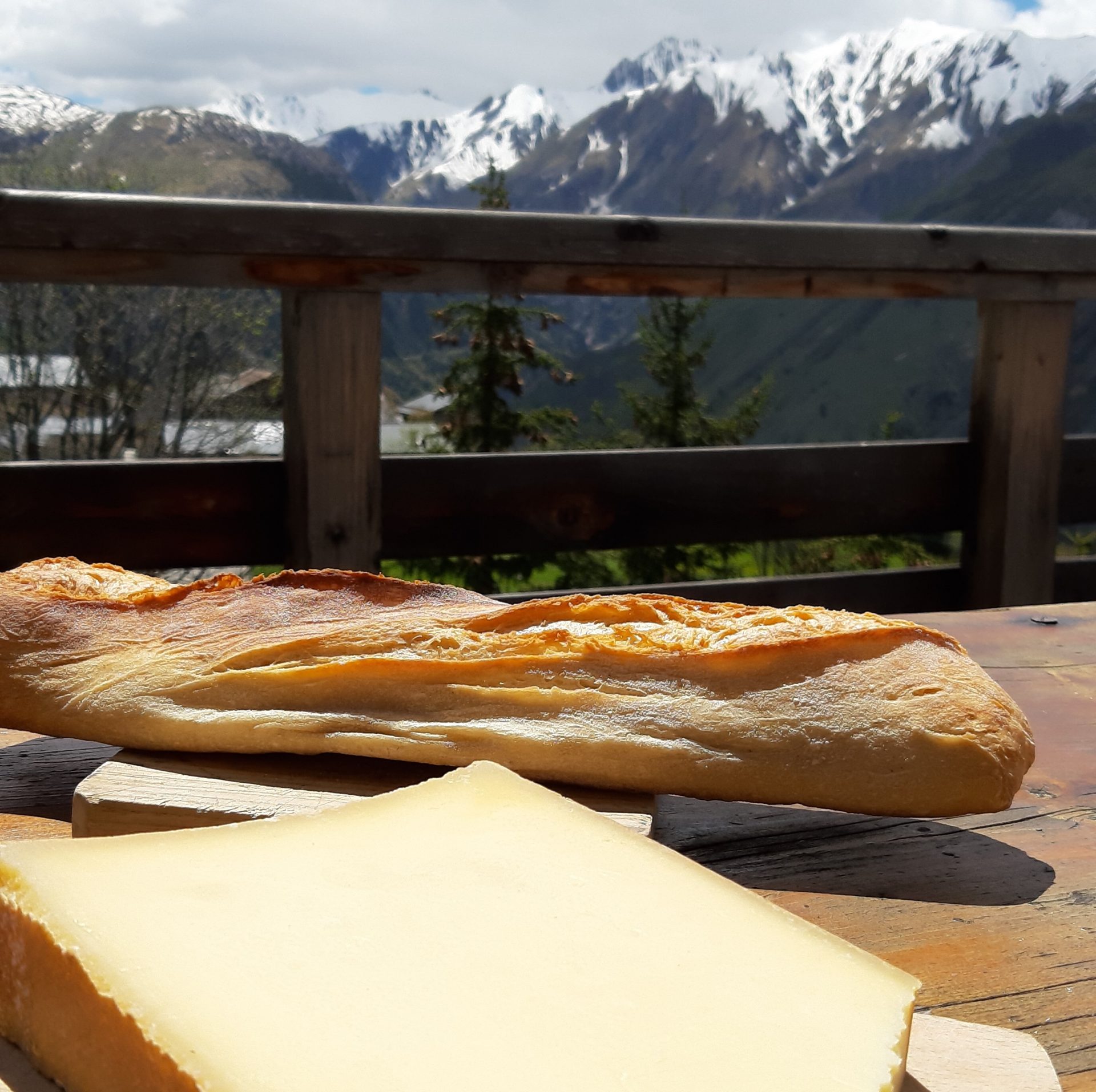 Baguette mit Käse auf einem Holztische in den Alpen