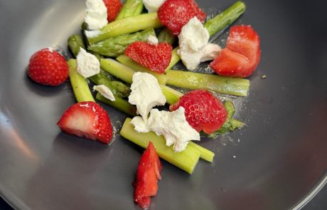 Dunkler Teller mit Spargel-Erdbeer-Ziegenkäsesalat